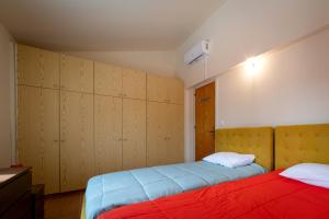 普拉特斯Hillside Home in Platres的一间卧室设有两张床和木制橱柜。