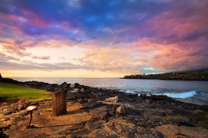 科纳OUTRIGGER Kona Resort and Spa的岩石海滩边的长凳