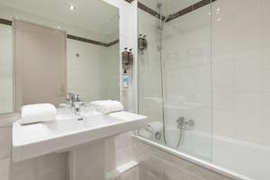 里昂Hôtel Charlemagne by Happyculture的白色的浴室设有水槽和淋浴。