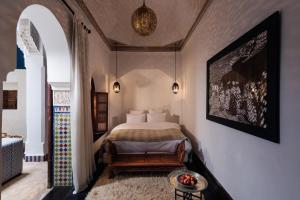 马拉喀什蓝眸摩洛哥传统庭院住宅的卧室配有一张床和一张桌子