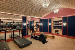 巴黎Le Grand Mazarin的一间健身房,内设健身器材,位于带蓝色墙壁的房间