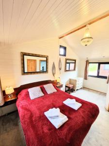 沃明斯特Beaver 1 HuntersMoon-warminster-Wiltshire的一间卧室配有红色大床和毛巾