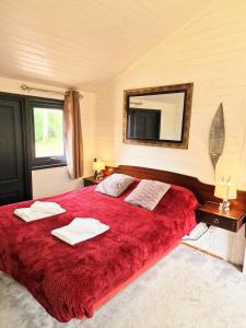 沃明斯特Beaver 1 HuntersMoon-warminster-Wiltshire的一间卧室配有一张红色大床和镜子