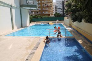 马赫姆拉阿伊冈公寓的男人和孩子在游泳池玩耍