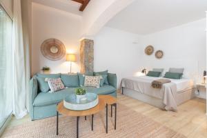 卡尔德斯德马拉维亚Bacom House completa的客厅配有蓝色的沙发和床。