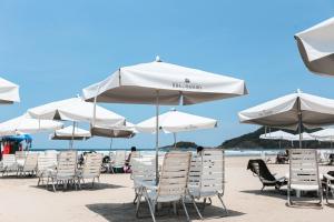圣劳伦斯海滨Pool Ilha da Madeira Resort的沙滩上的一把椅子和遮阳伞