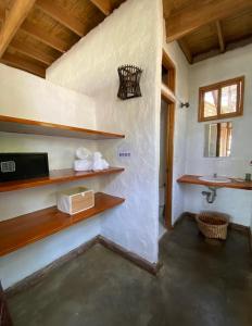 曼克拉Bungalows Las Balsas的浴室设有水槽和带毛巾的架子。