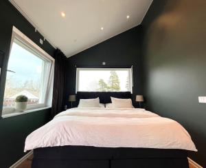 斯德哥尔摩Luxury Villa with Jacuzzi的一间卧室设有一张大床和一个窗户。