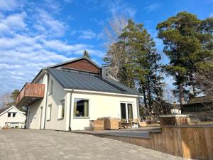 斯德哥尔摩Luxury Villa with Jacuzzi的一间黑色屋顶的白色小房子
