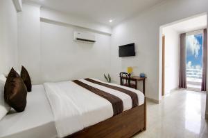 古尔冈Niketan Medanta Service Apartment - A BOUTIQUE HOTEL的白色的卧室设有床和窗户