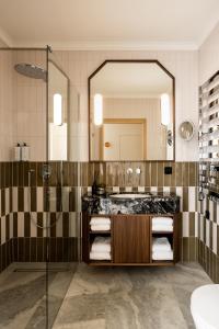 克拉科夫Zinar Castle的带淋浴、盥洗盆和镜子的浴室