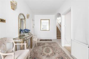 Maida ValeLarge 5 Bedroom house in Finchley的白色走廊,配有桌椅和镜子