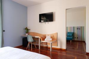 布拉恰诺HA Hotel的一间卧室配有一张桌子、一把椅子和一台电视机