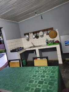 贝岛Bungalow chez Mouch Nosy-Be 4的一间带桌子的厨房和一间带炉灶的厨房