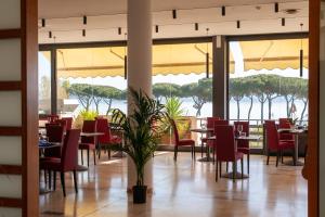布拉恰诺HA Hotel的一间带桌椅并享有水景的餐厅