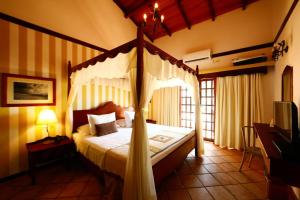 纳塔尔马纳里普莱雅酒店的一间卧室,卧室内配有一张天蓬床