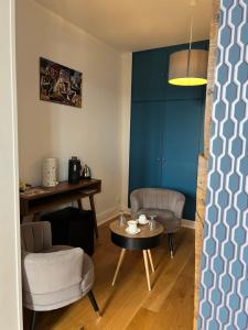 埃佩尔奈Le Clos d 'Aÿ的客厅配有桌椅和蓝色的墙壁