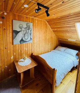 RugājiViesu nams RŪĶĪŠI的木制客房内的一间卧室,配有一张床