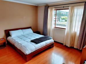 昆卡Casa Quirola hermosa y muy grande的一间卧室设有一张大床和窗户