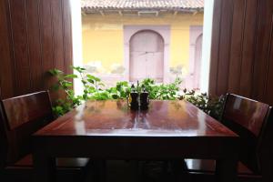 莱昂Hotel and Coffe Azul的窗户客房内的木桌