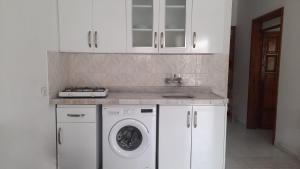 厄吕代尼兹Sarıhan Apart Otel的厨房配有洗衣机和水槽
