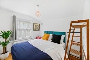 伦敦Cosy Urban Oasis 2 Bedroom Flat in Tottenham ( Sleeps 5 People )的卧室配有蓝色和白色的床和梯子