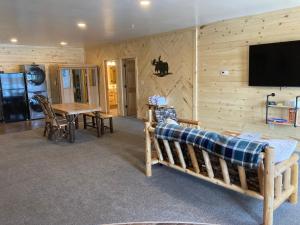 霍顿Keweenaw Waters Resort的客房设有木墙、一张床和一张桌子。