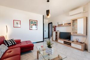 莫诺波利Casa Nilla的客厅配有红色沙发和电视