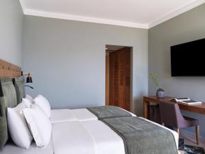 伊斯米亚Kalamaki Beach Resort的一间卧室配有一张床、一张书桌和一台电视
