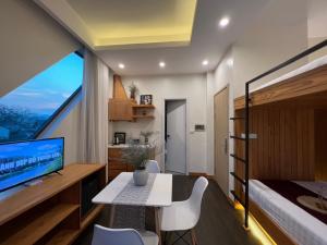 大叻Hanoi Amsterdam Condotel的一间卧室配有一张床和一张书桌及电视