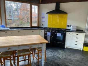 阿维莫尔Cairngorm Lodge Rothiemurchus的厨房配有炉灶和木桌。