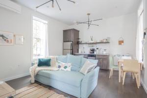 卡温顿Pastel Paradise - Adorable Covington Apartment的一间带蓝色沙发的客厅和一间厨房