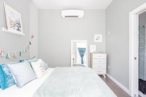 卡温顿Pastel Paradise - Adorable Covington Apartment的白色卧室配有白色床和蓝色枕头