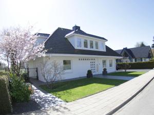 蒂门多弗施特兰德Techts Landhus Birkenallee的白色的房子,设有园景庭院