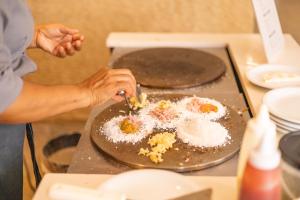 马塞约圣马力诺套房酒店的把鸡蛋放在柜台上的盘子里的人