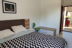 隆德里纳novinha, aconchegante e moderna!的一间卧室配有一张带黑白毯子的床