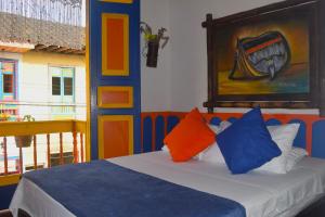 菲兰迪亚FILANDIA HOTEL的一间卧室配有带色彩缤纷枕头的床