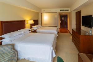 门多萨门多萨喜来登酒店的酒店客房设有两张床和一台平面电视。