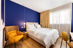Giv‘atayimSirkin 16 Hotel - Autonomous hotel的一间卧室设有一张床和蓝色的墙壁