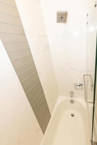 联城Amusing 2-bedroom haven close to New york city的带淋浴的浴室配有白色浴缸。