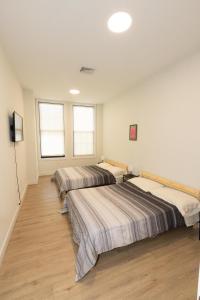 联城Amusing 2-bedroom haven close to New york city的三个床在一间房间里排成一排