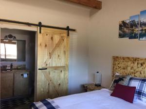 埃斯卡兰特Ponderosa Inn的一间卧室设有滑动谷仓门和一张床