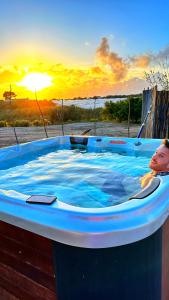 圣玛丽亚德尔法加洛Ciriga Sicily Glamping Resort的儿童在热水浴池中,欣赏日落美景