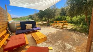 雅弗尼Dome in the Olive Grove כיפה גיאודזית ענקית ומודרנית בין עצי הזית的一个带蓝色沙发和野餐桌的庭院