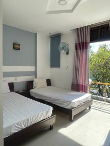 岘港CÁT TƯỜNG MOTEL的两张床位于带窗户的房间内