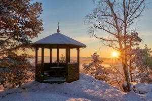 DoubiceHotel Jef a Krčma u Rytíře的雪地凉亭,背景是日落