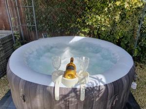 卢顿Sally's bed and breakfast的热水浴池,内含一瓶香槟