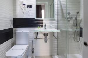 马德里格兰大街44号旅馆的浴室配有卫生间、盥洗盆和淋浴。