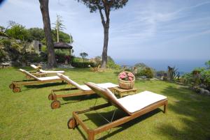 马尔恰纳Hotel Sant'Andrea的院子里草地上的三张躺椅