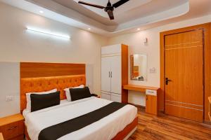 加济阿巴德Super OYO Flagship Red Diamond Hotel的一间卧室配有一张大床和木制床头板